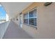 Exterior hallway featuring windows and a white railing with water views in this tan condo complex at 1847 Shore S Dr # 507, South Pasadena, FL 33707