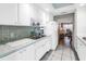 Bright kitchen featuring white cabinets, stainless steel sink, and access to living area at 1847 Shore S Dr # 507, South Pasadena, FL 33707