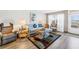 Living room featuring wood floors and bright furniture with a door to the exterior hallway at 1847 Shore S Dr # 507, South Pasadena, FL 33707