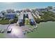 Aerial view of a beachfront condo complex, featuring a pool, boat docks, and stunning water views at 19531 Gulf Blvd # 210, Indian Shores, FL 33785
