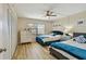 Comfortable bedroom with two beds, ceiling fan, modern dresser and bright natural light at 19531 Gulf Blvd # 210, Indian Shores, FL 33785