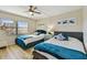 Bright bedroom featuring two beds, a ceiling fan, and ample natural light from the large window at 19531 Gulf Blvd # 210, Indian Shores, FL 33785