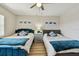 A bedroom featuring two beds, a center nightstand with lamp, and ocean-themed decor at 19531 Gulf Blvd # 210, Indian Shores, FL 33785