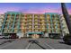Condo with teal accents, black railings, multi-story, and parking spaces for residents and guests at 19531 Gulf Blvd # 210, Indian Shores, FL 33785