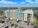Exterior of the condo building with private balconies, parking and lush tropical landscaping at 19531 Gulf Blvd # 210, Indian Shores, FL 33785