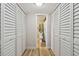 Hallway view of a half bathroom with louvered closet doors on either side at 19531 Gulf Blvd # 210, Indian Shores, FL 33785