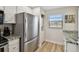 Bright kitchen featuring a stainless steel refrigerator and a laundry area at 19531 Gulf Blvd # 210, Indian Shores, FL 33785