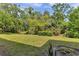 Wide shot of the green backyard, surrounded by mature trees at 2005 Greenbriar Blvd # 7, Clearwater, FL 33763