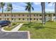 Inviting two-story condo building with a well-maintained lawn and beautiful landscaping at 2005 Greenbriar Blvd # 7, Clearwater, FL 33763