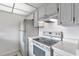 Kitchen with white cabinetry, appliances, tile backsplash, and lots of counter space at 2005 Greenbriar Blvd # 7, Clearwater, FL 33763
