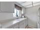 A bright kitchen with a double basin sink, white countertops, and checkered window valance at 2005 Greenbriar Blvd # 7, Clearwater, FL 33763