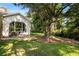 Picturesque backyard view showcasing lush green grass, mature trees, a deck, and natural surroundings at 20403 Walnut Grove Ln, Tampa, FL 33647
