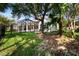 Beautiful backyard with a screened lanai, lush grass, mature trees, and a black fence, offering privacy at 20403 Walnut Grove Ln, Tampa, FL 33647