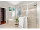 Bathroom with large tub, shower, glass block window, closet, and white towels hanging on rack at 20403 Walnut Grove Ln, Tampa, FL 33647