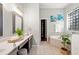 Bathroom with a bathtub, large mirror, tiled floor, walk-in closet, and a glass block window at 20403 Walnut Grove Ln, Tampa, FL 33647
