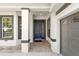 Front entrance with a blue door, beige stone floors, and dark window and door trim at 20403 Walnut Grove Ln, Tampa, FL 33647