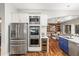 Modern kitchen with stainless steel appliances, wine cooler, white cabinetry, and a view of the living room at 20403 Walnut Grove Ln, Tampa, FL 33647