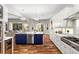 Bright kitchen with a navy island, stainless steel appliances, white cabinets and hardwood floors at 20403 Walnut Grove Ln, Tampa, FL 33647