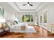 Main bedroom featuring hardwood floors, tray ceilings, large windows, french doors, and natural light at 20403 Walnut Grove Ln, Tampa, FL 33647