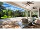 Large screened lanai offers brick pavers, ceiling fans, and a relaxing outdoor living space in a backyard setting at 20403 Walnut Grove Ln, Tampa, FL 33647