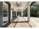 Screened-in lanai with brick pavers, ceiling fans, and furniture to relax, complemented by backyard views at 20403 Walnut Grove Ln, Tampa, FL 33647