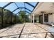 Screened patio boasting brick pavers, ceiling fans and lush greenery, creating an inviting outdoor retreat at 20403 Walnut Grove Ln, Tampa, FL 33647