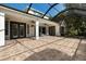 Expansive screened lanai features brick pavers, multiple doors to the home, and ceiling fans for relaxing at 20403 Walnut Grove Ln, Tampa, FL 33647