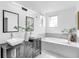 This bathroom features double sinks, framed mirrors, and a soaking tub with a decorative plant at 2410 W North A St # 2, Tampa, FL 33609