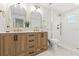 Bright bathroom featuring a wooden vanity with double sinks, gold fixtures, and a walk-in shower at 3066 Highland N St, St Petersburg, FL 33704