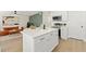 Open-concept area showcasing the kitchen island with stainless appliances and living room featuring unique wall decor at 3066 Highland N St, St Petersburg, FL 33704