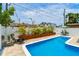 Backyard with a refreshing pool, tropical plants, and seating area, perfect for outdoor relaxation and entertaining at 3066 Highland N St, St Petersburg, FL 33704
