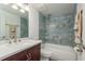 Updated bathroom offers a tub and shower combo and blue marble-look tile surround at 311 Island Way # 101, Clearwater Beach, FL 33767