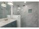 This updated bathroom showcases unique tiling and a glass shower enclosure at 311 Island Way # 101, Clearwater Beach, FL 33767