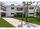 Elegant condo exterior featuring a private balcony, lush greenery, and a brick pathway at 311 Island Way # 101, Clearwater Beach, FL 33767