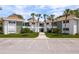 Exterior view of condo buildings featuring a parking area and well-maintained landscaping at 311 Island Way # 101, Clearwater Beach, FL 33767