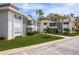 Exterior view of the condo buildings set back from parking with mature landscaping at 311 Island Way # 101, Clearwater Beach, FL 33767
