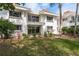 Exterior of the home featuring a balcony above a covered patio with mature landscaping at 311 Island Way # 101, Clearwater Beach, FL 33767