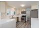 Updated kitchen boasts stainless steel appliances, white cabinets, and quartz countertops at 311 Island Way # 101, Clearwater Beach, FL 33767