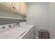 Convenient laundry room with upper cabinets and modern washer and dryer at 311 Island Way # 101, Clearwater Beach, FL 33767