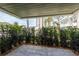 Shaded outdoor patio space surrounded by greenery and stone walkway at 311 Island Way # 101, Clearwater Beach, FL 33767