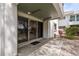 A covered patio featuring tiled flooring leads inside, set within a landscaped yard at 311 Island Way # 101, Clearwater Beach, FL 33767