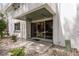 A covered patio with tiled flooring leading into the home, surrounded by a landscaped area at 311 Island Way # 101, Clearwater Beach, FL 33767