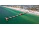 A beautiful aerial view of a long pier extending into the water with a building at the end at 311 Island Way # 101, Clearwater Beach, FL 33767