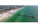 A beautiful aerial view of a long pier extending into the water, with buildings on the end of the pier at 311 Island Way # 101, Clearwater Beach, FL 33767