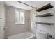 Clean bathroom with tiled walls, shower and tub combo, and decorative floating shelves at 3206 W Azeele St # 126, Tampa, FL 33609