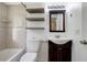 Beautiful bathroom with tiled walls, dark vanity, sink, decorative floating shelves, and a toilet at 3206 W Azeele St # 126, Tampa, FL 33609