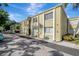 Two-story condo building with a pale yellow exterior and mature landscaping at 3206 W Azeele St # 126, Tampa, FL 33609
