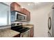 Charming kitchen features granite countertops, wood cabinetry, and stainless steel appliances at 3206 W Azeele St # 126, Tampa, FL 33609