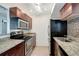 Charming kitchen features granite countertops, wood cabinetry, and stainless steel appliances at 3206 W Azeele St # 126, Tampa, FL 33609