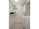 A compact laundry room with a stacked washer and dryer unit, and shelving at 3206 W Azeele St # 126, Tampa, FL 33609